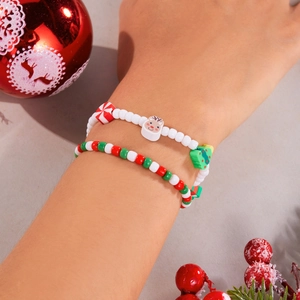 Detail of handmade Christmas beaded bracelets with reindeer charms on a model's wrist