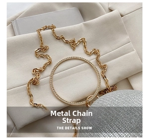 Detail of elegant gold metal chain strap and rhinestone round handle on silver evening bag