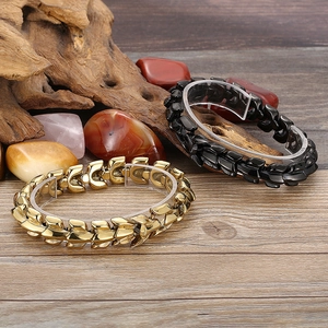 Detail of gold and black dragon bone bracelets on acrylic stand with natural wood background