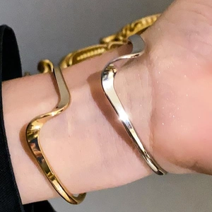 Modern wavy irregular polished metal open bangles in gold and silver finish for women