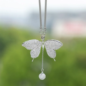 Close-up of sparkling rhinestone butterfly pendant with crystal ball for car decor