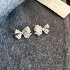 Elegant 14K gold plated silver bow earrings with brushed texture and tiny rhinestones