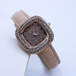 Macro shot of rose gold square watch case with diamonds and beige leather strap