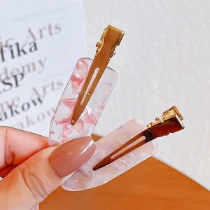 Set of two pink seamless hair clips with gold metal base and clear resin finish