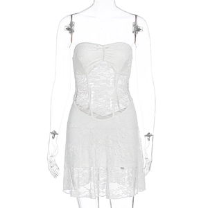 Close-up of white lace tube dress featuring corset boning and bow detail on the chest