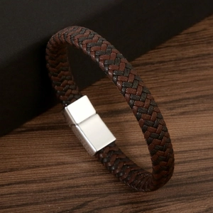 Classic braided leather couple bracelet with magnetic alloy clasp on rustic wood