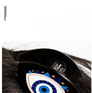 Detail shot of black acrylic evil eye hair claw clip showing pattern and polished finish