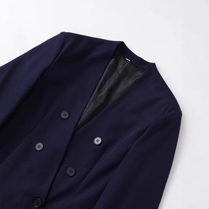 Giacca blazer blu scuro senza colletto con fodera nera e bottoni su sfondo bianco