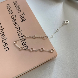 Macro detail of 925 silver knot bracelet with adjustable chain and spring clasp