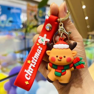 Close-up of a brown cartoon reindeer keychain with a red silicone strap for Christmas