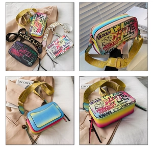 Detail of colorful graffiti crossbody bag with dual zippers and wide woven strap