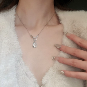 Close-up of a silver gourd pendant necklace with zircon inlay on a female neck