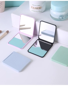 Macro view of portable square folding makeup mirrors in pink, blue, green, and black
