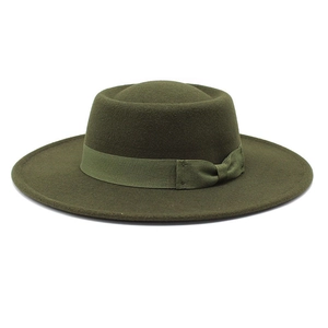 Detailed macro view of dark green wool fedora hat with flat brim and decorative ribbon