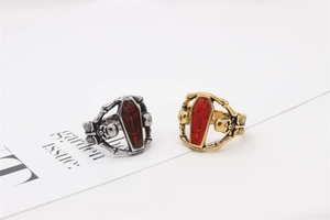 Detail of gothic coffin rings with red inlay and skull carvings in gold and silver finish