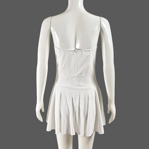 Back view of a white ribbed knit tube dress showing the pleated hem on a mannequin