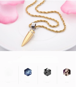 Detail of a bullet-shaped pendant with crystal ring on a twisted chain over a ceramic plate