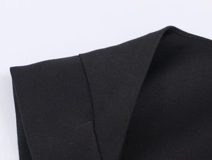 Nahaufnahme der schwarzen Strickstruktur und hochwertigen Nähte des kurzen Jumpsuits