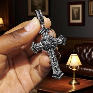 Detailed close-up of a silver cross pendant inlaid with black zircon and rectangular gems