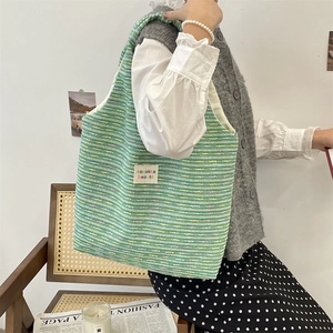 Detail of green knit tote bag with sozakka beauté embroidery and weave texture