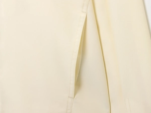 Macro shot of fine stitching on beige bomber jacket with premium woven texture