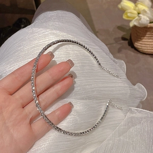 Vue rapprochée du collier de strass étincelants avec chaîne réglable sur tissu blanc