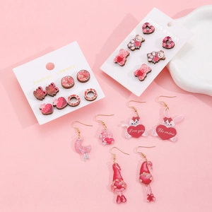Flat lay of Valentine's Day acrylic earrings with heart, bear, and rabbit designs