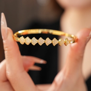 Macro shot of gold-plated fan-shaped bracelet links with sparkling pavé zircon stones