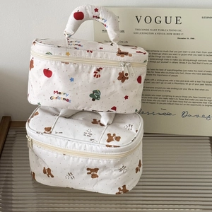 Quilted makeup bags with Christmas dachshund and bear prints, stacked on a magazine background