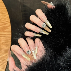 Long almond press-on nails with nude pink cat eye gradient and crystal heart accent