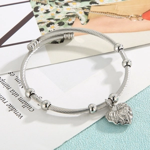 Detail of twisted wire silver stainless steel bracelet with engraved heart charm