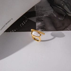Detail view of gold stainless steel ring with baroque pearl and artistic wrap lines