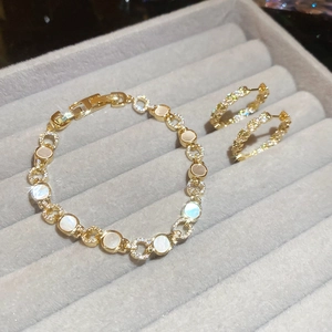 Parure bijoux dorée avec incrustations de nacre et cristaux dans un coffret en velours