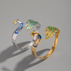 Close-up of vintage peacock cuff bracelets with colorful enamel and 18K gold plating