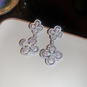 Macro shot of silver four-leaf clover drop earrings with brilliant pavé crystals