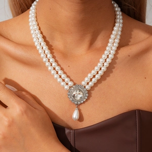Detail of bohemian double-layer pearl necklace with turquoise and rhinestone teardrop pendant