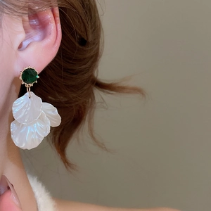 Detail of elegant pearl petal earrings featuring green stone and gold-tone finish
