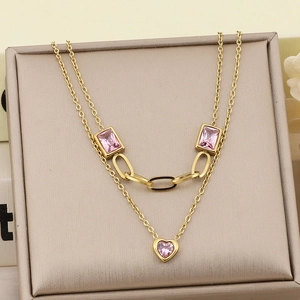 Detail of double-layer gold chain with pink heart pendant and rectangular zircon stones