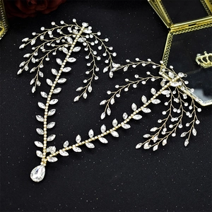 Golden bridal hair vine with sparkling rhinestones and teardrop pendant on black background