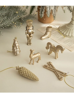Detail of 7 champagne gold Christmas ornaments including reindeer and nutcracker figures