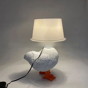 Macro shot of white resin chicken lamp base with detailed feather textures and orange claws
