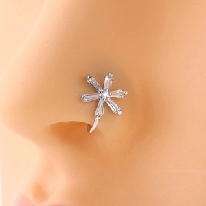 Detail of silver flower nose clip with clear crystals shown on a model without piercing