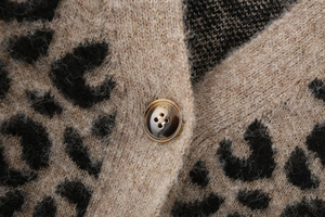 Vue macro de la maille léopard avec un bouton marron marbré de haute qualité sur le gilet