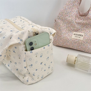 Close-up of floral canvas lunch bag with side pocket for mobile phone storage