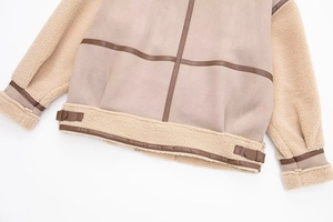 Detail of faux shearling hem and brown adjustable leather buckles on aviator jacket