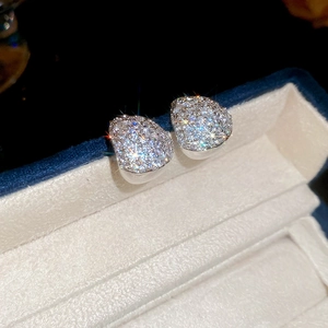 Macro shot of sparkling zircon teardrop stud earrings in a premium jewelry gift box