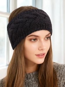 Detail of dark knit headband featuring a classic thick cable pattern and warm fleece lining