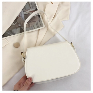 Minimalist beige PU leather shoulder bag shown on a stylish blazer with magazine props