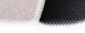 Macro detail of plush white rug featuring anti-slip backing and reinforced stitched edges
