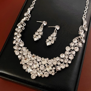 Detailed view of silver diamond geometric jewelry set on a black leather gift box